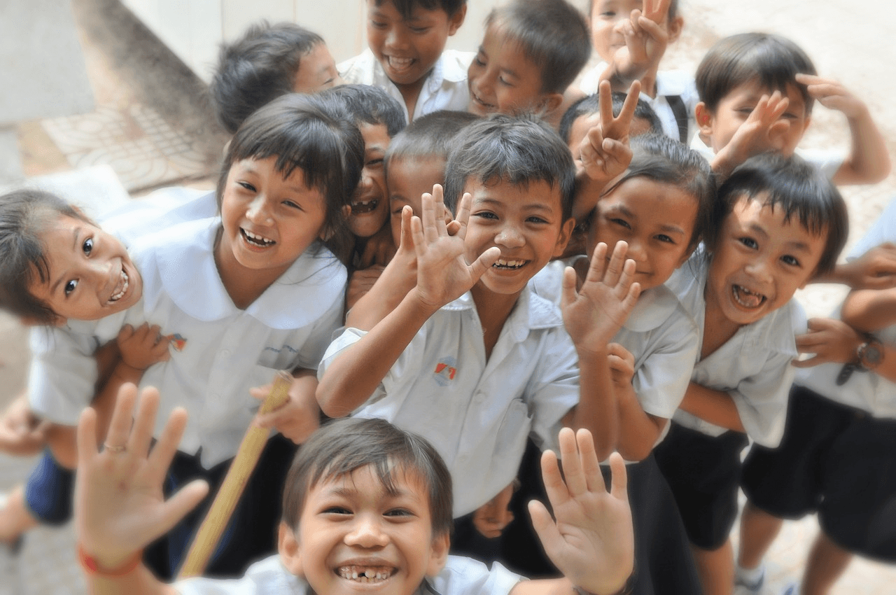 Smiling children in the background.